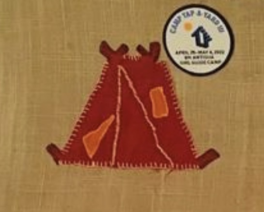 Quilted panel of a red Guide tent with orange windows, stitched onto a tan background, with a small commemorative camp badge in the upper corner.