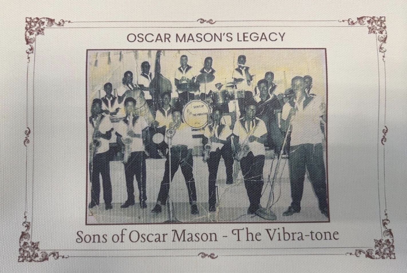 Vintage photograph of the Sons of Oscar Mason – The Vibra-tones, a large family band posed with brass, string, and percussion instruments, framed by an ornate decorative border